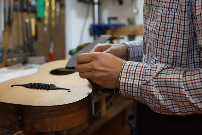 Florian Brandstätter repariert ein Musikinstrument in seiner Werkstatt